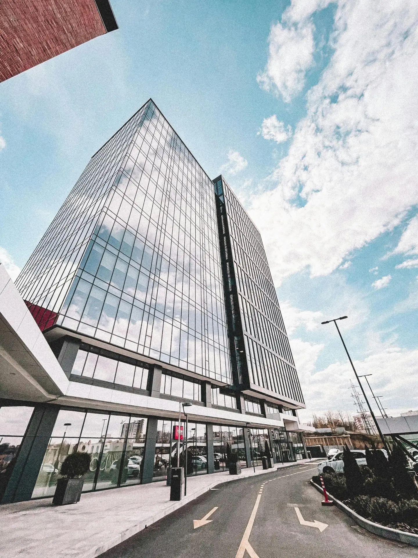 Contemporary glass office tower reflecting the sky, showcasing modern architectural design.