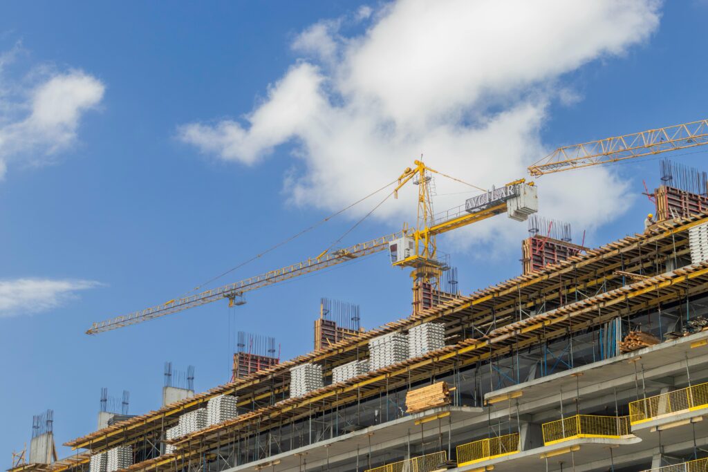 Contact Jem Prime Limited. modern construction site with cranes against a clear blue sky, showcasing urban development.